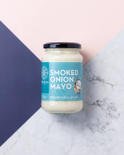 Jar of smoked onion mayo on a marble surface with a colorful background