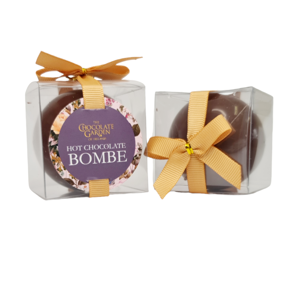 A gift box containing two servings of Chocolate Garden Hot Chocolate Bombe, with a floral design on the box and a golden bow on top.