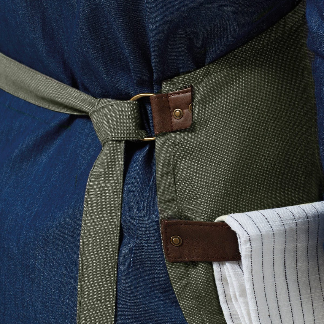 Close up of forest apron against a denim background with a teatowel