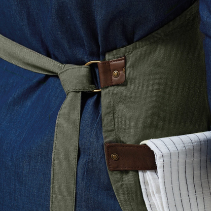 Close up of forest apron against a denim background with a teatowel