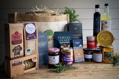 Assorted food products including jars, boxes, and bottles on a wooden surface with a white background.