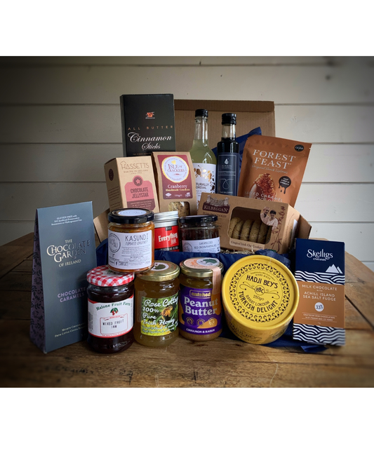 Assorted food products including jars, boxes, and bottles on a wooden surface with a white background.