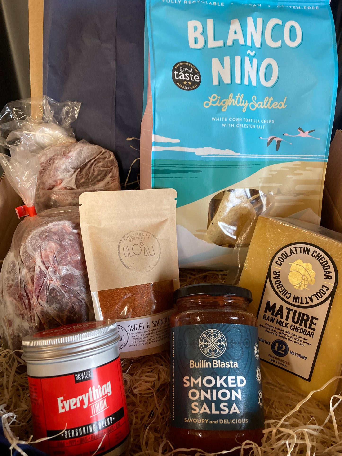 Assorted food items including Blanco Niño, cheese, salsa, and other packaged goods on a textured surface.