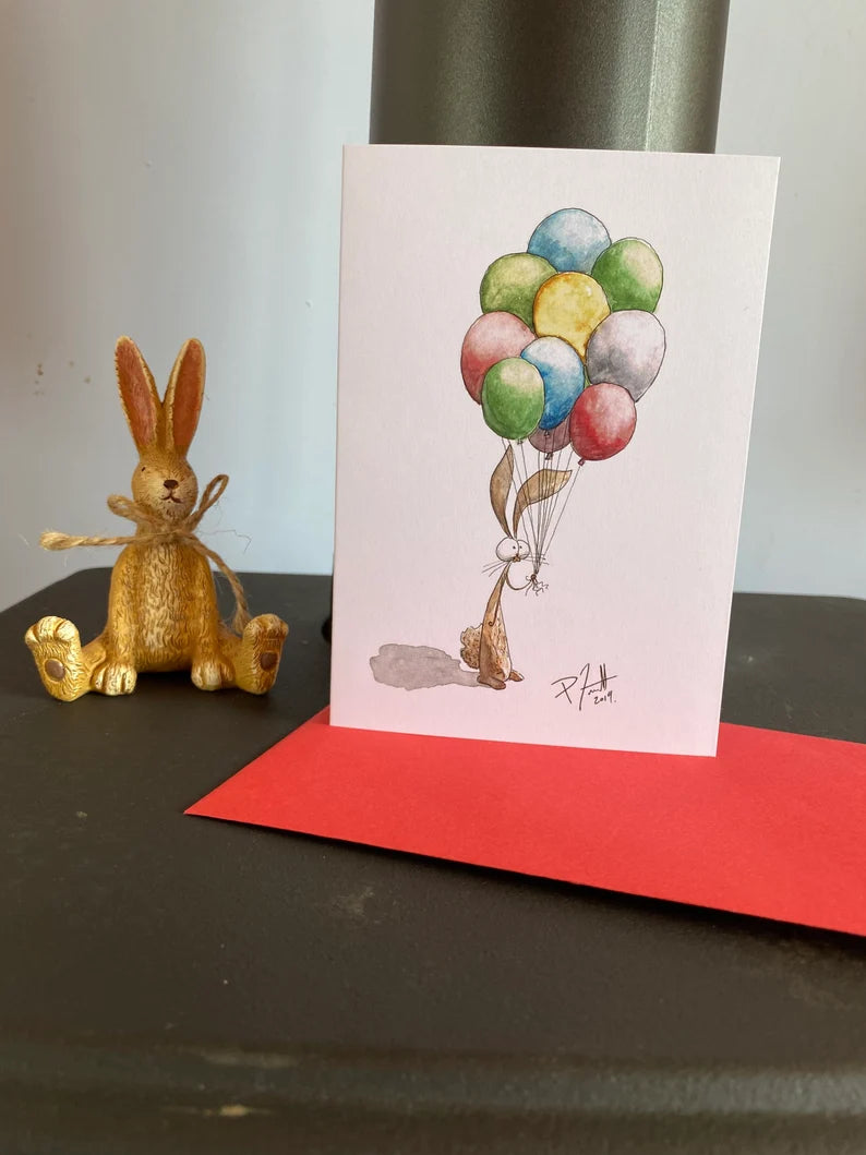 Card with a rabbit holding a bunch of balloons