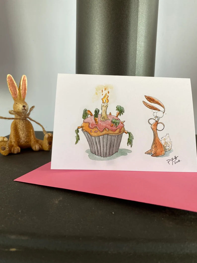 Card with a rabbit looking at a birthday carrot cake
