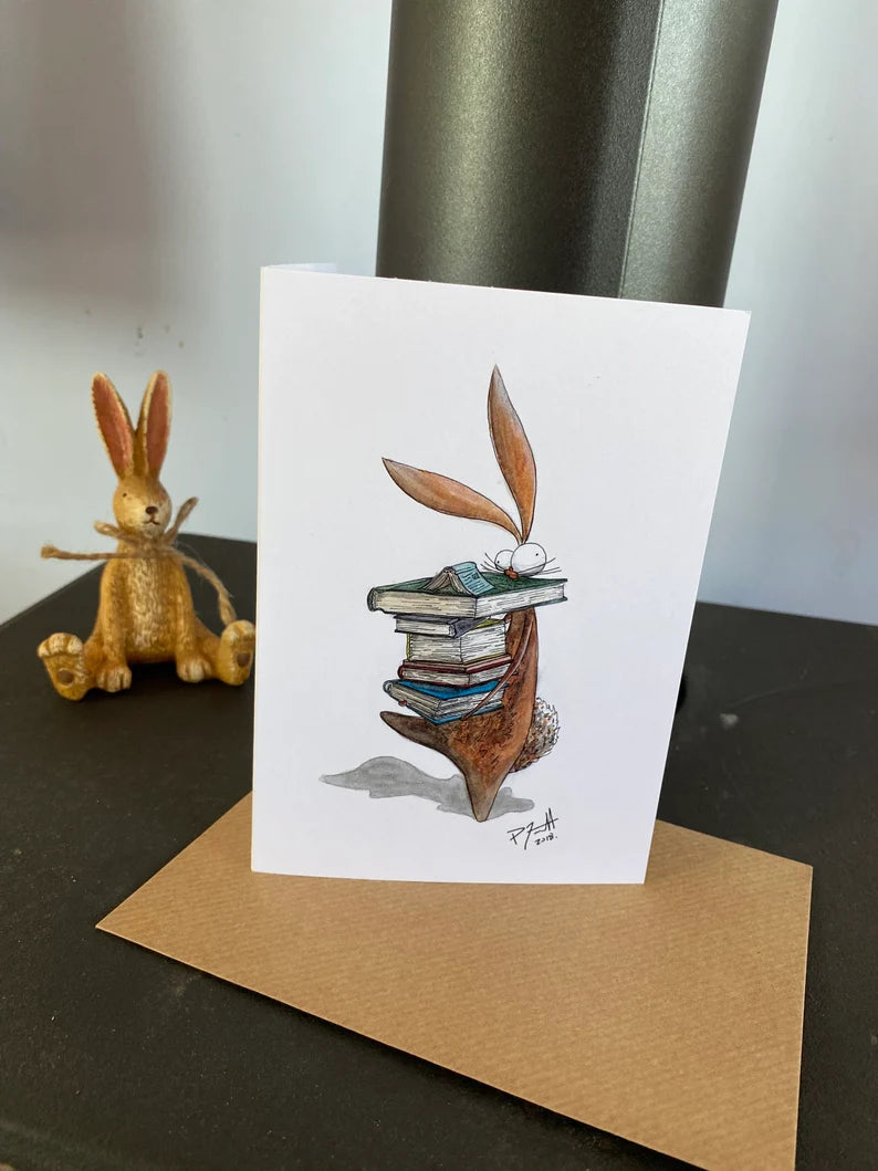 Card with a rabbit carrying a pile of books