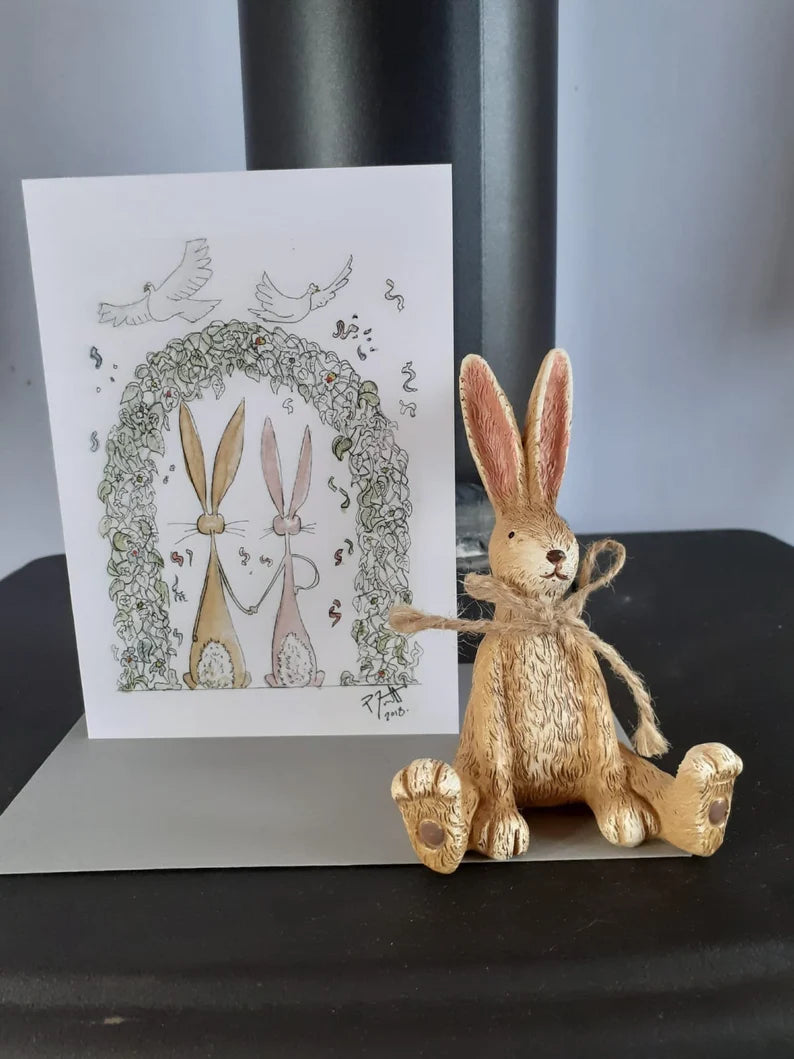 Card with two rabbits under a wedding arch