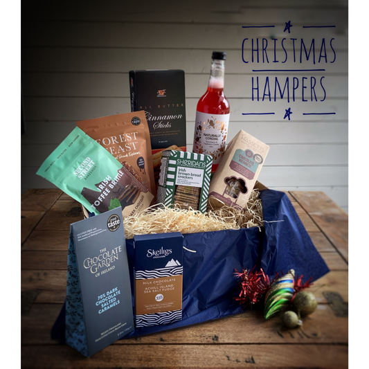 Christmas hampers with various items on a wooden table